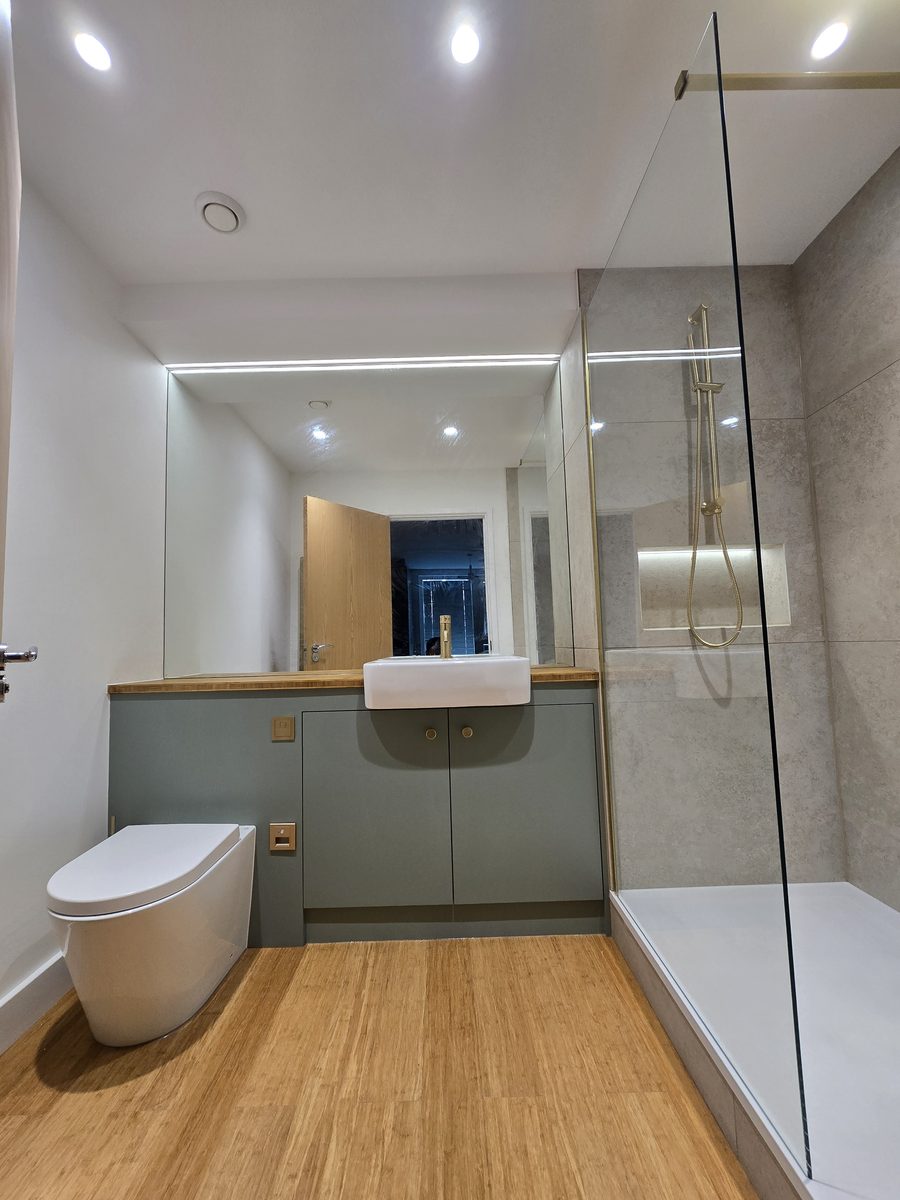 Dalston en-suite bathroom with sage green vanity, glass shower screen and brushed brass fittings