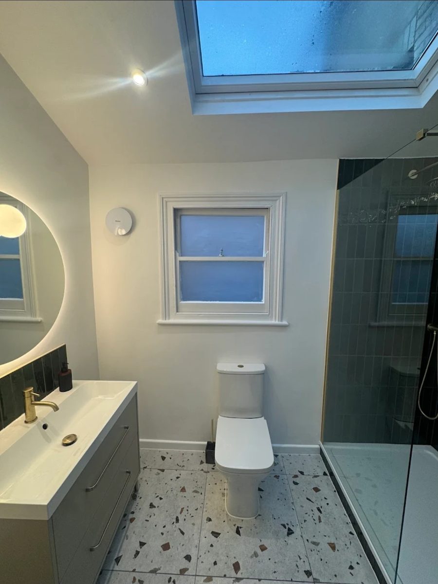 Peckham bathroom renovation with green metro tiling and terrazzo-effect flooring