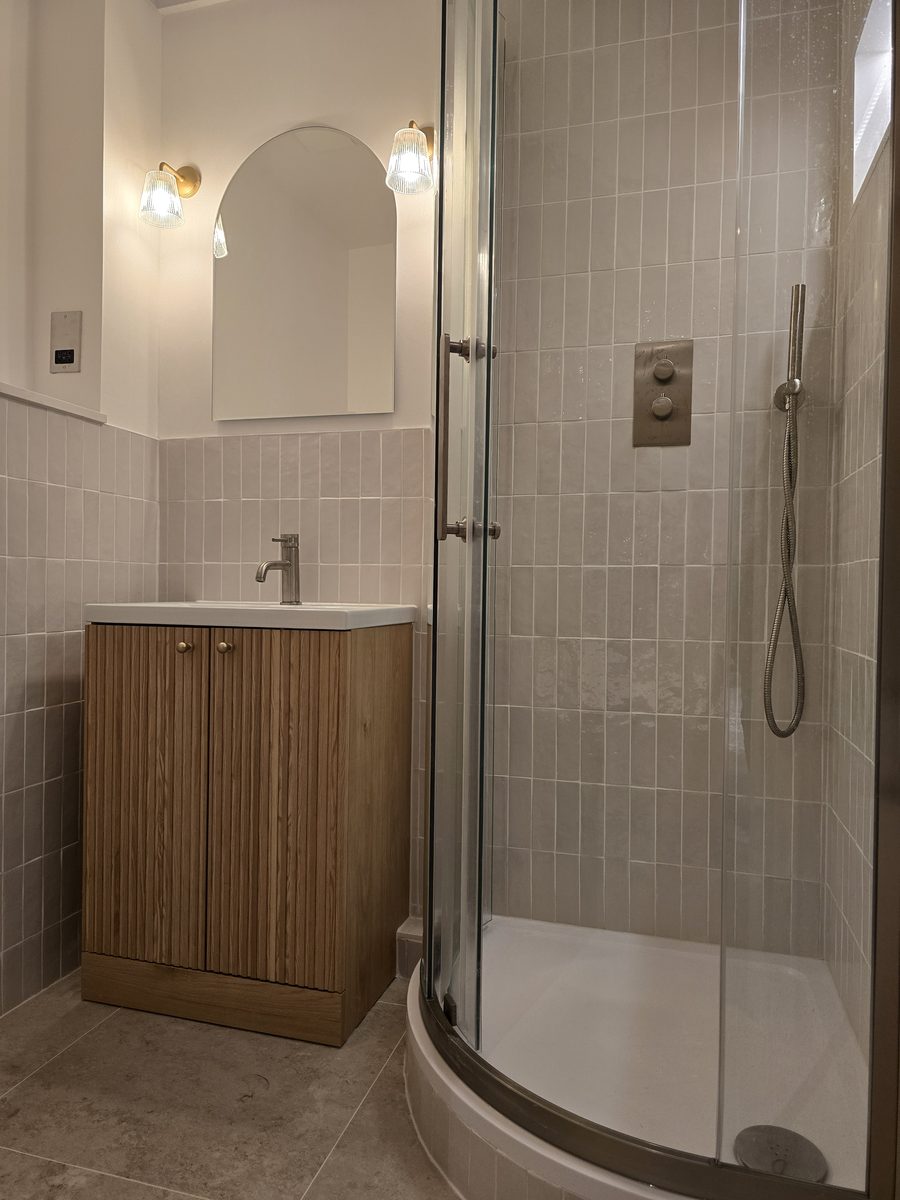 Rotherhithe bathroom wide view showing vanity, arched mirror and curved shower