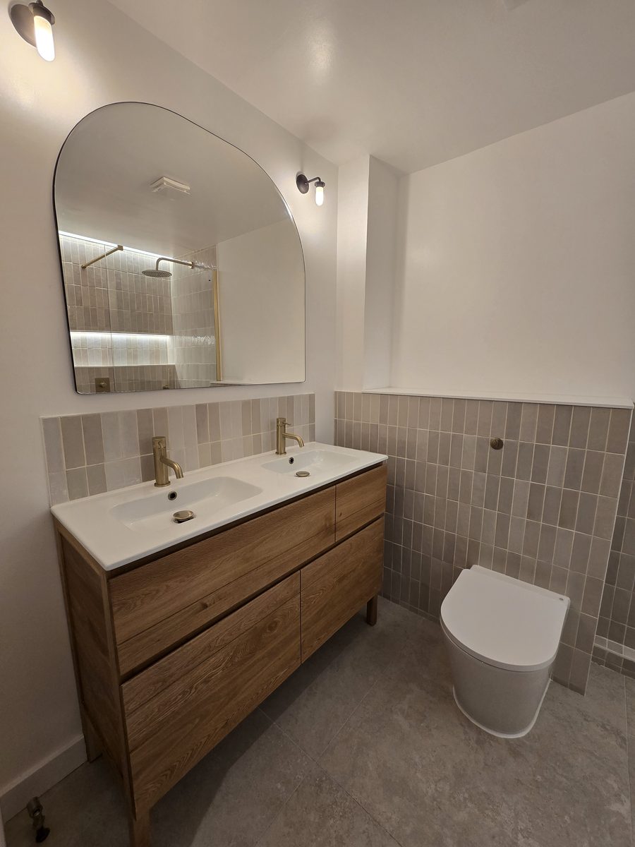 Rotherhithe second bathroom with double basin oak vanity, gold fittings and arched mirror